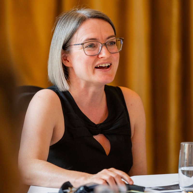 Anna Ambrose, a white woman with short light hair and glasses